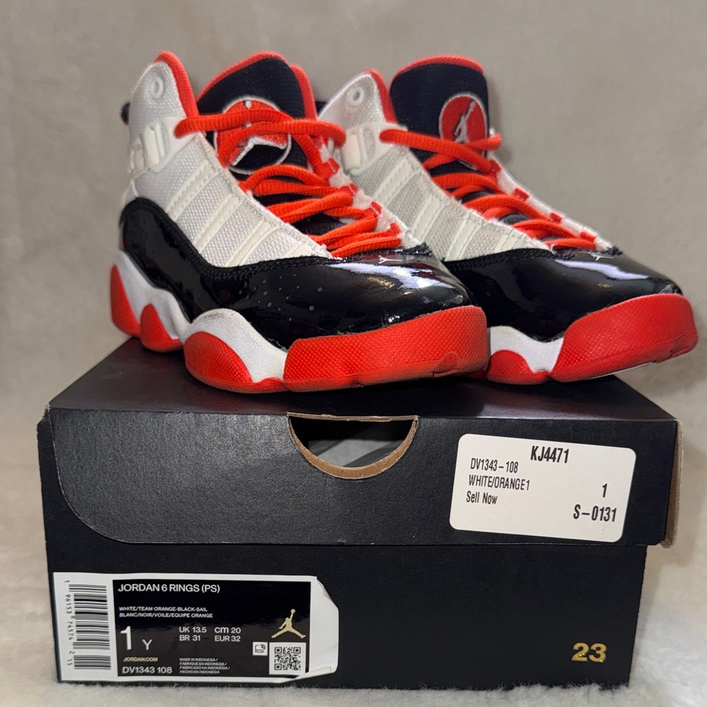 Jordan Kids Sneakers in Black, White, and Orange. Comes with box.